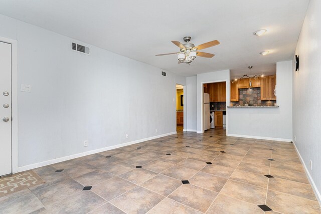 unfurnished living room featuring light tile patterned floors and ceiling fan