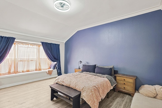 bedroom with wood-type flooring, crown molding, and lofted ceiling