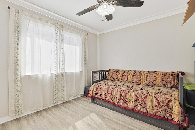 bedroom featuring light hardwood / wood-style flooring, ceiling fan, and crown molding