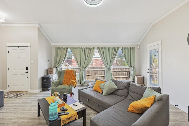 living room with light hardwood / wood-style flooring, lofted ceiling, and ornamental molding