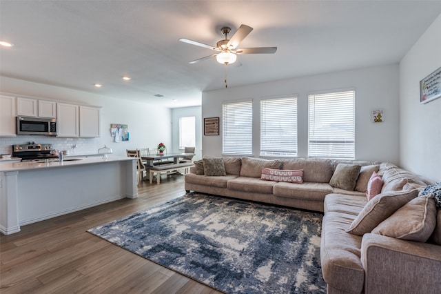 living room featuring ceiling fan and dark hardwood / wood-style flooring