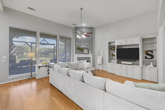 living room featuring light hardwood / wood-style flooring and ceiling fan