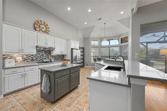 kitchen featuring white cabinets, sink, an island with sink, and light wood-type flooring