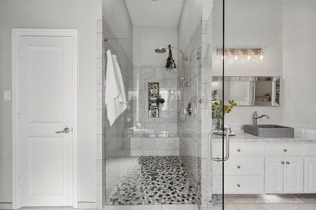 bathroom with tile patterned flooring, vanity, and an enclosed shower