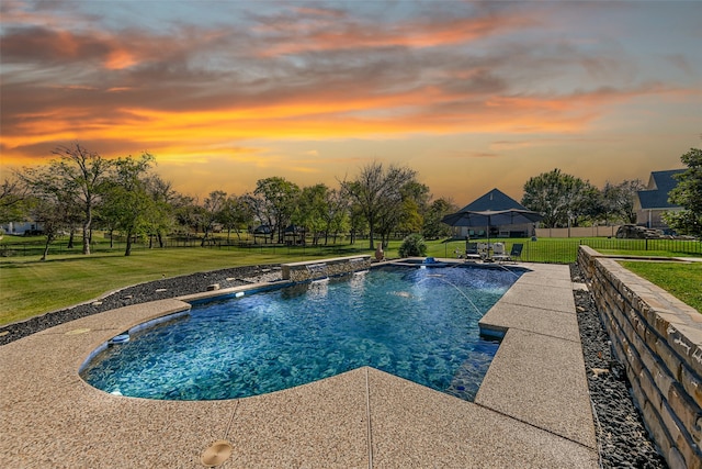 pool at dusk featuring a gazebo, pool water feature, and a yard