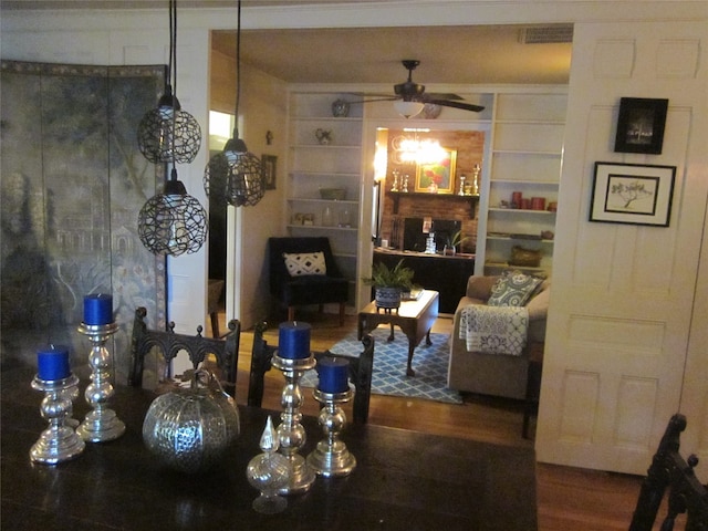 dining space with wood-type flooring, built in features, and ceiling fan