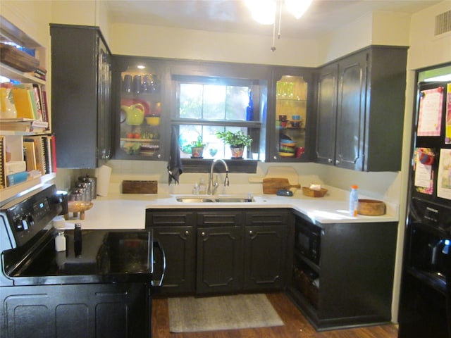 kitchen with wood-type flooring, refrigerator, black range with electric stovetop, and sink