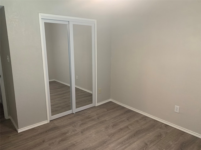 unfurnished bedroom with a closet and hardwood / wood-style floors