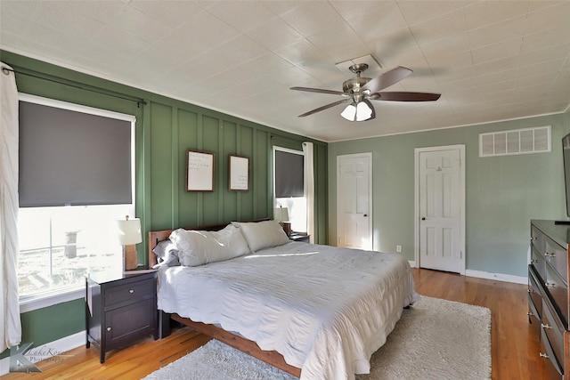 bedroom with light wood finished floors, baseboards, and visible vents