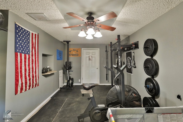 exercise area featuring ceiling fan and a textured ceiling