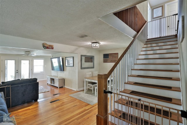 interior space featuring french doors, a textured ceiling, and hardwood / wood-style flooring