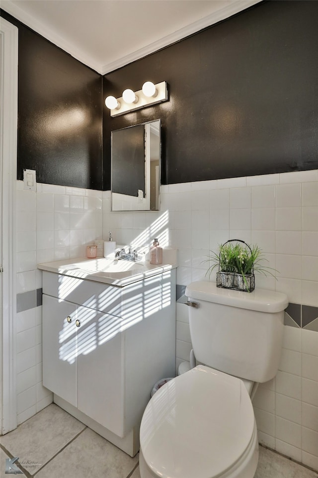 bathroom featuring tile patterned flooring, vanity, tile walls, and toilet