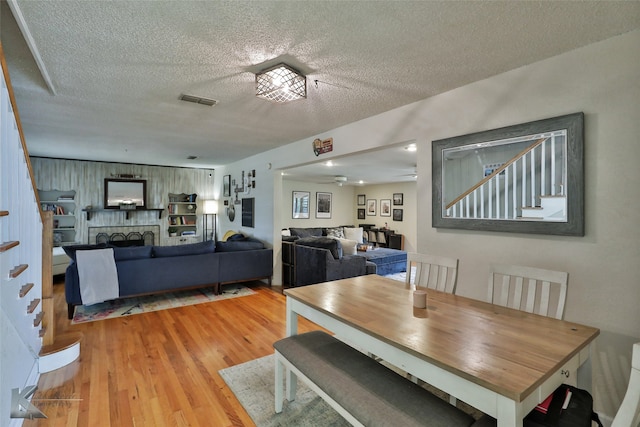 dining room featuring a textured ceiling, hardwood / wood-style flooring, and ceiling fan