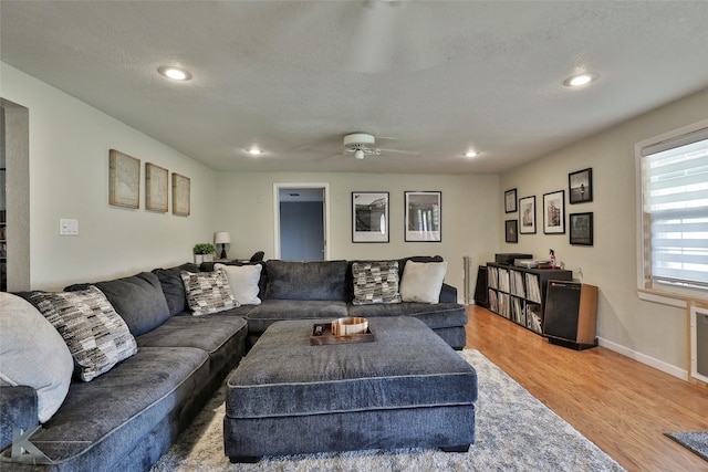 living room with ceiling fan, hardwood / wood-style floors, and a textured ceiling