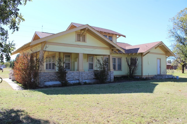 231 N 3rd Ave, Munday, TX 76371 - view of front of house with a front yard, stone siding, and a shingled roof
