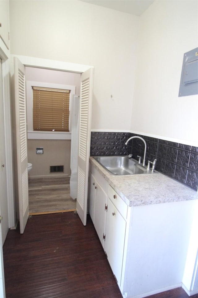 231 N 3rd Ave, Munday, TX 76371 - bathroom with wood finished floors, vanity, and electric panel