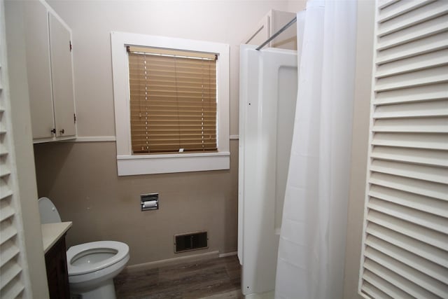 231 N 3rd Ave, Munday, TX 76371 - full bathroom featuring tile walls, wood finished floors, toilet, vanity, and a shower with shower curtain