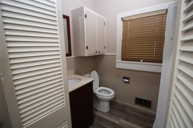 231 N 3rd Ave, Munday, TX 76371 - bathroom featuring wood finished floors, toilet, vanity, and baseboards