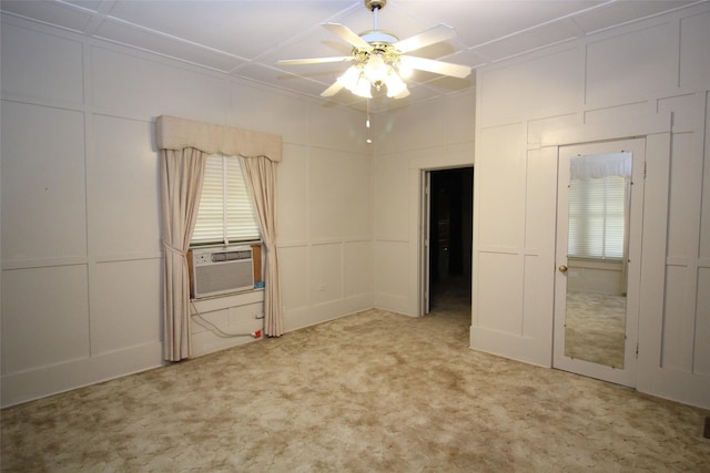 231 N 3rd Ave, Munday, TX 76371 - unfurnished bedroom with a decorative wall, carpet flooring, cooling unit, ceiling fan, and multiple windows