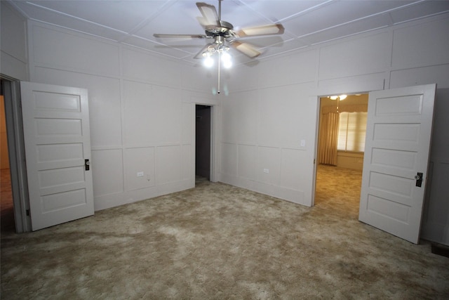231 N 3rd Ave, Munday, TX 76371 - unfurnished bedroom with a decorative wall, carpet, and a ceiling fan