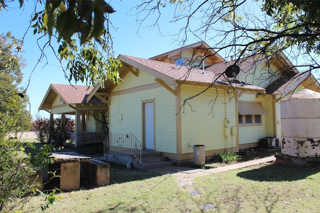 231 N 3rd Ave, Munday, TX 76371 - rear view of house featuring a yard and roof with shingles