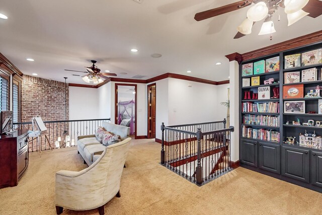 living area with light carpet, ceiling fan, and crown molding