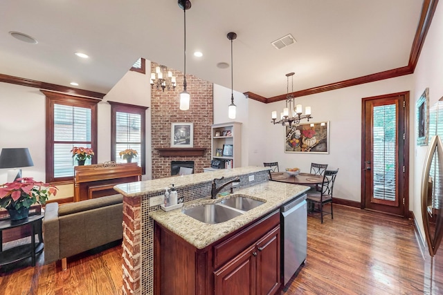 kitchen with sink, hanging light fixtures, stainless steel dishwasher, a fireplace, and wood-type flooring