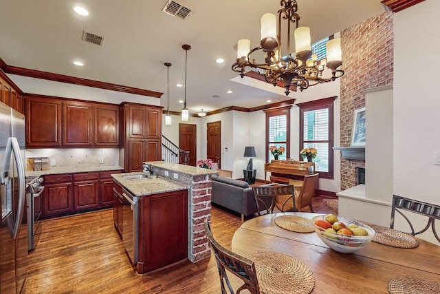 kitchen featuring ornamental molding, light wood-type flooring, hanging light fixtures, and a notable chandelier