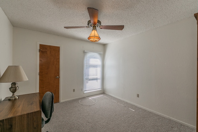 unfurnished office with a textured ceiling, ceiling fan, and carpet flooring