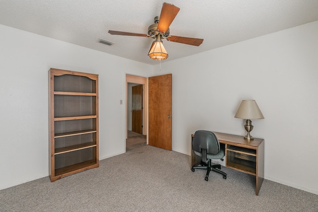 carpeted office space with a textured ceiling and ceiling fan