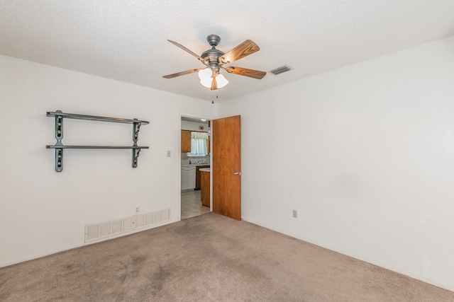 carpeted spare room with ceiling fan and a textured ceiling