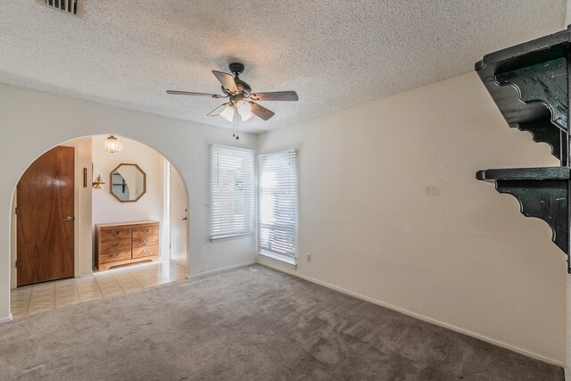 unfurnished living room with light carpet, a textured ceiling, and ceiling fan