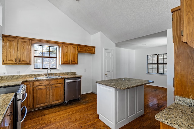 kitchen with a kitchen island, sink, appliances with stainless steel finishes, and dark wood-type flooring