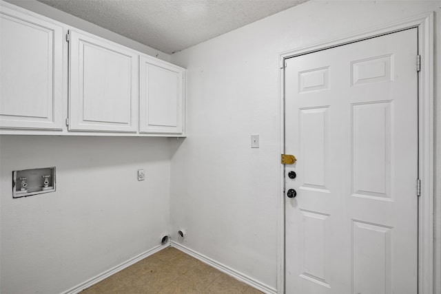 laundry area featuring hookup for a washing machine, cabinets, a textured ceiling, and hookup for an electric dryer