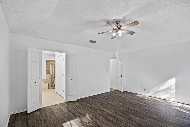 empty room featuring lofted ceiling, ceiling fan, hardwood / wood-style floors, and a textured ceiling