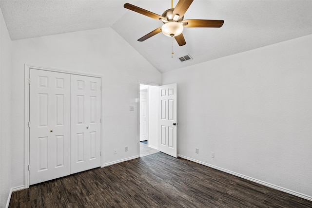 unfurnished bedroom with ceiling fan, dark hardwood / wood-style flooring, high vaulted ceiling, and a closet