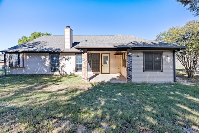 rear view of property with a patio and a lawn