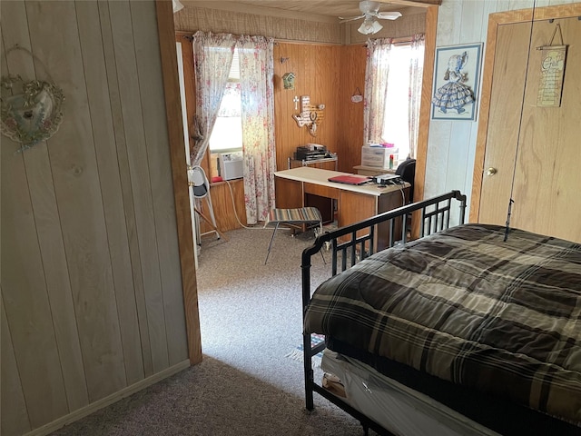 bedroom with cooling unit, wood walls, carpet floors, and ceiling fan