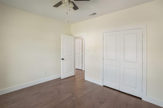 unfurnished bedroom featuring ceiling fan, dark wood-type flooring, and a closet