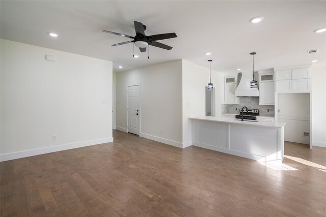 kitchen featuring custom exhaust hood, ceiling fan, decorative backsplash, decorative light fixtures, and white cabinetry