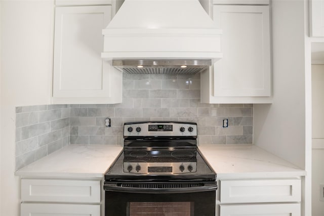 kitchen with backsplash, stainless steel electric range oven, white cabinets, and custom range hood