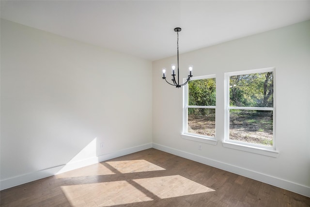 unfurnished dining area featuring a notable chandelier, wood-type flooring, and plenty of natural light