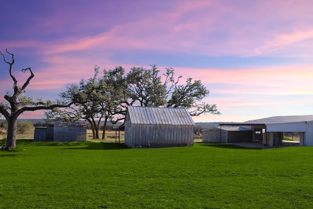 yard at dusk featuring an outbuilding