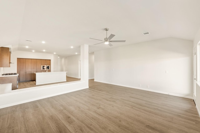 unfurnished living room featuring lofted ceiling, visible vents, light wood-style flooring, and recessed lighting