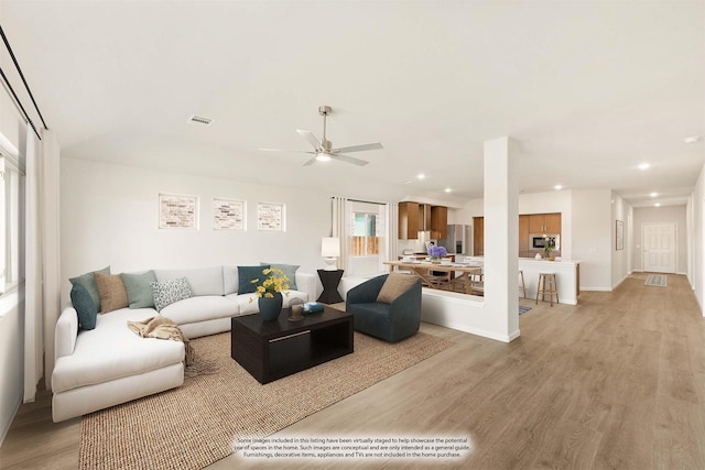 living room featuring light wood-style floors, recessed lighting, visible vents, and a ceiling fan