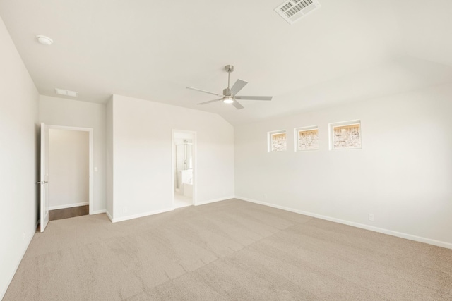 unfurnished bedroom with carpet flooring, vaulted ceiling, visible vents, and baseboards