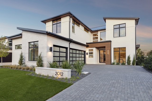 contemporary home featuring a garage and a yard