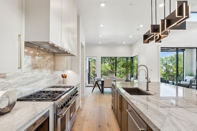 kitchen featuring light stone countertops, appliances with stainless steel finishes, plenty of natural light, and sink