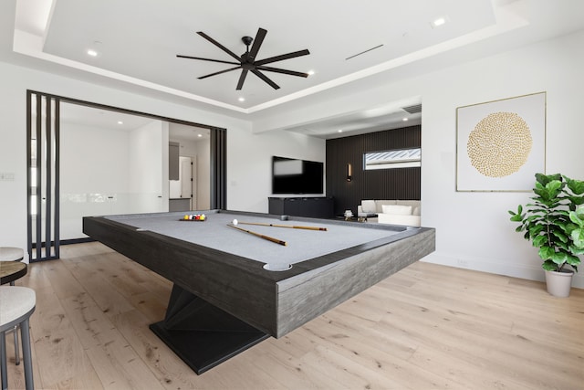 game room with billiards, light hardwood / wood-style flooring, ceiling fan, and a tray ceiling