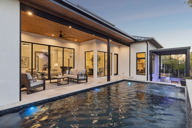 back house at dusk featuring an outdoor living space, a patio, and ceiling fan